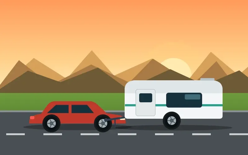 A car towing a caravan on a coastal road